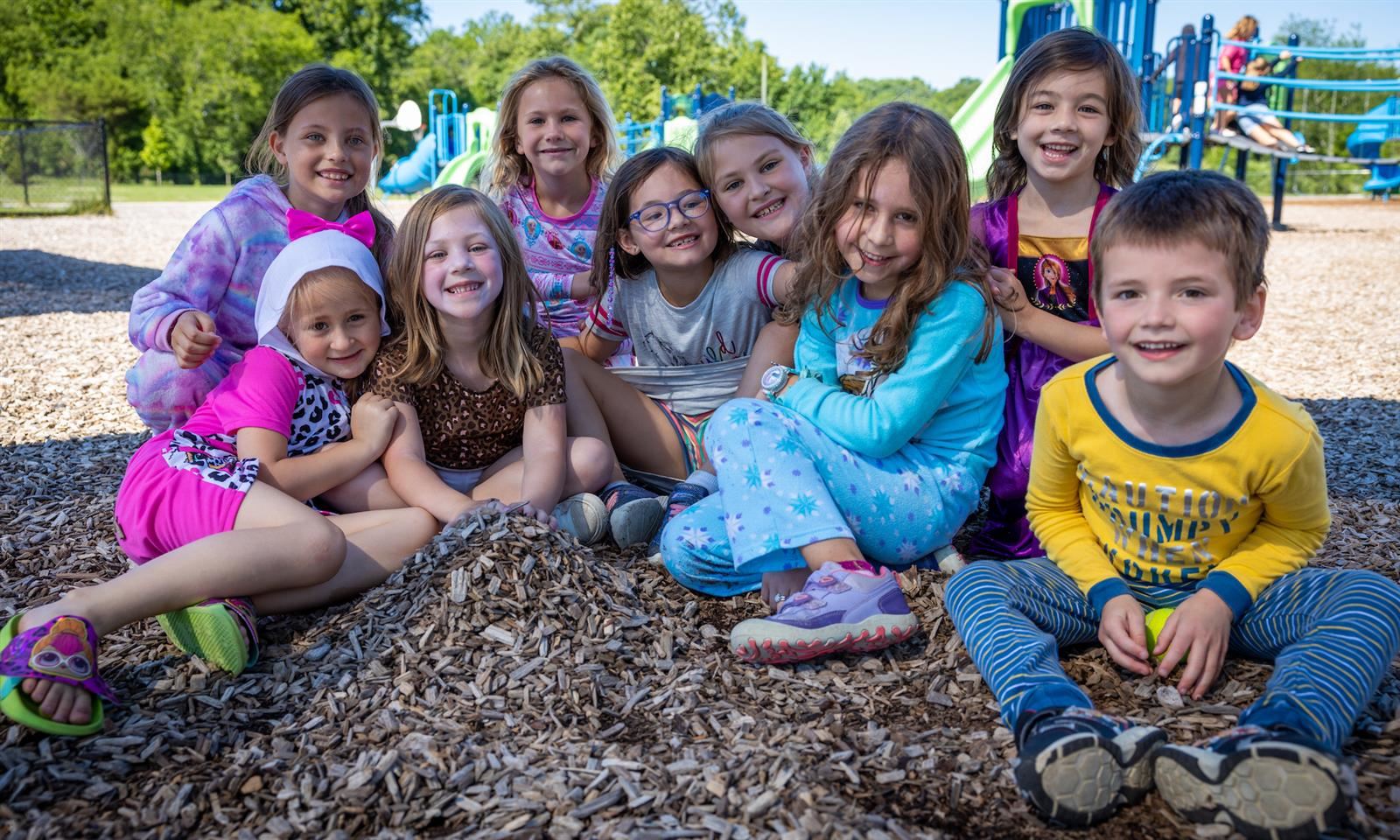 A group of students smile on the playground